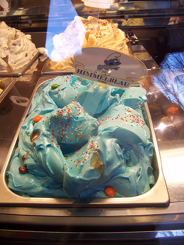 Bola de helado de pitufo de color azul intenso servida en tarrina